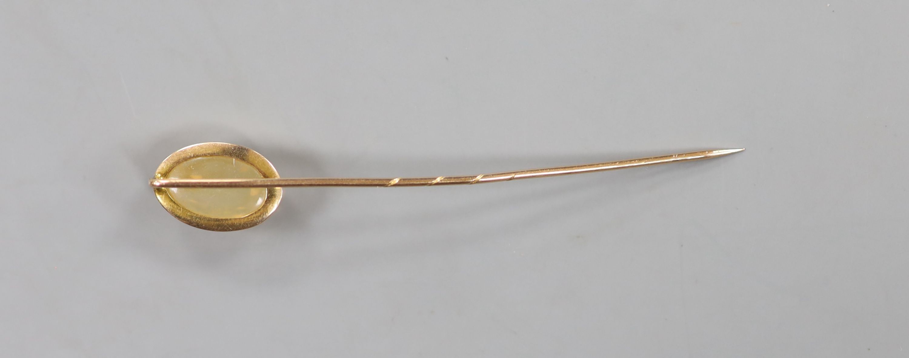 An early 20th century yellow metal and opal? set stick pin, 7cm, gross weight 2.4 grams.